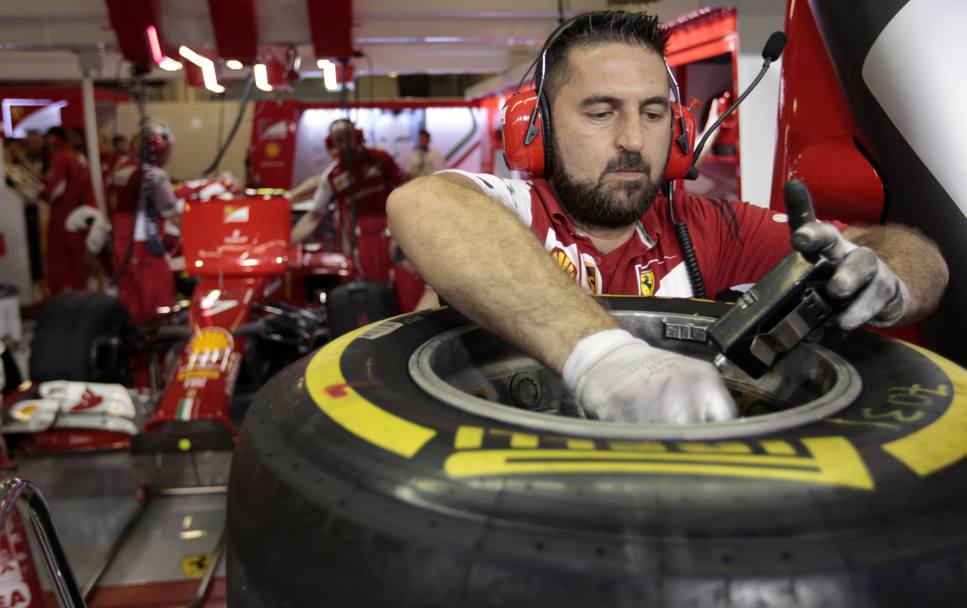 Un meccanico Ferrari controlla le gomme di Kimi Raikkonen, durante la seconda sessione di prove. (Action Images)